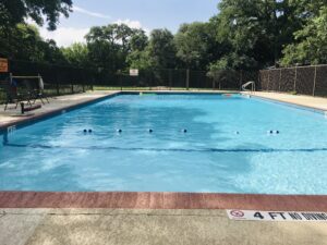 A commercial pool surrounded by a blue fence, showcasing a clean and inviting swimming area for relaxation and enjoyment